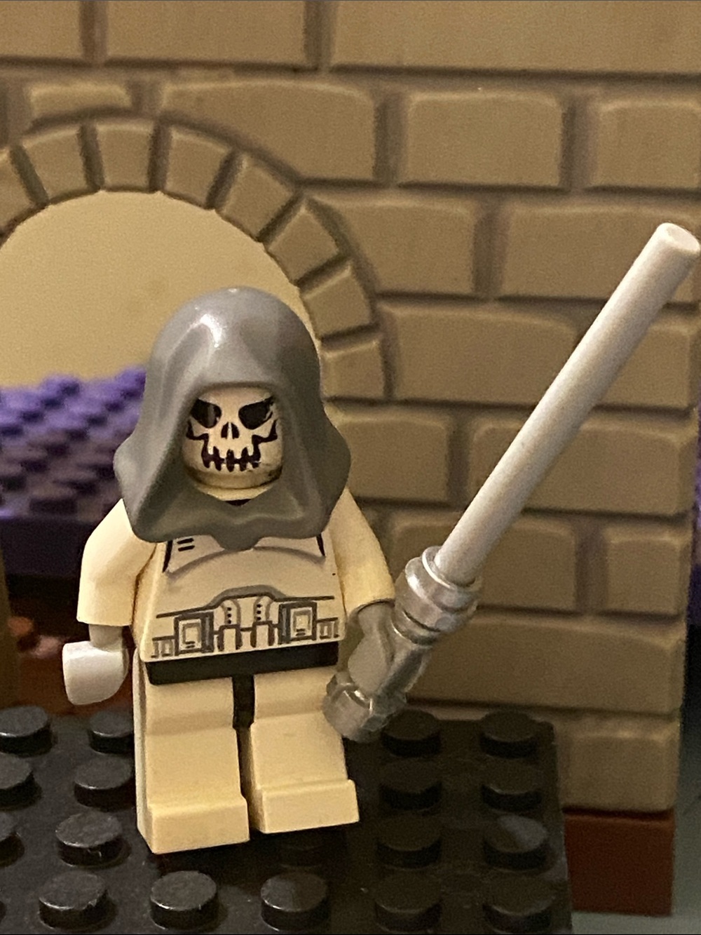 Lego skeleton-head minifigure with gray hood